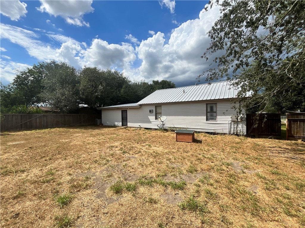 305 East Laredo Street Freer, TX 78357 - Photo 4 of 19 a backyard of a house with table and chairs under an umbrella