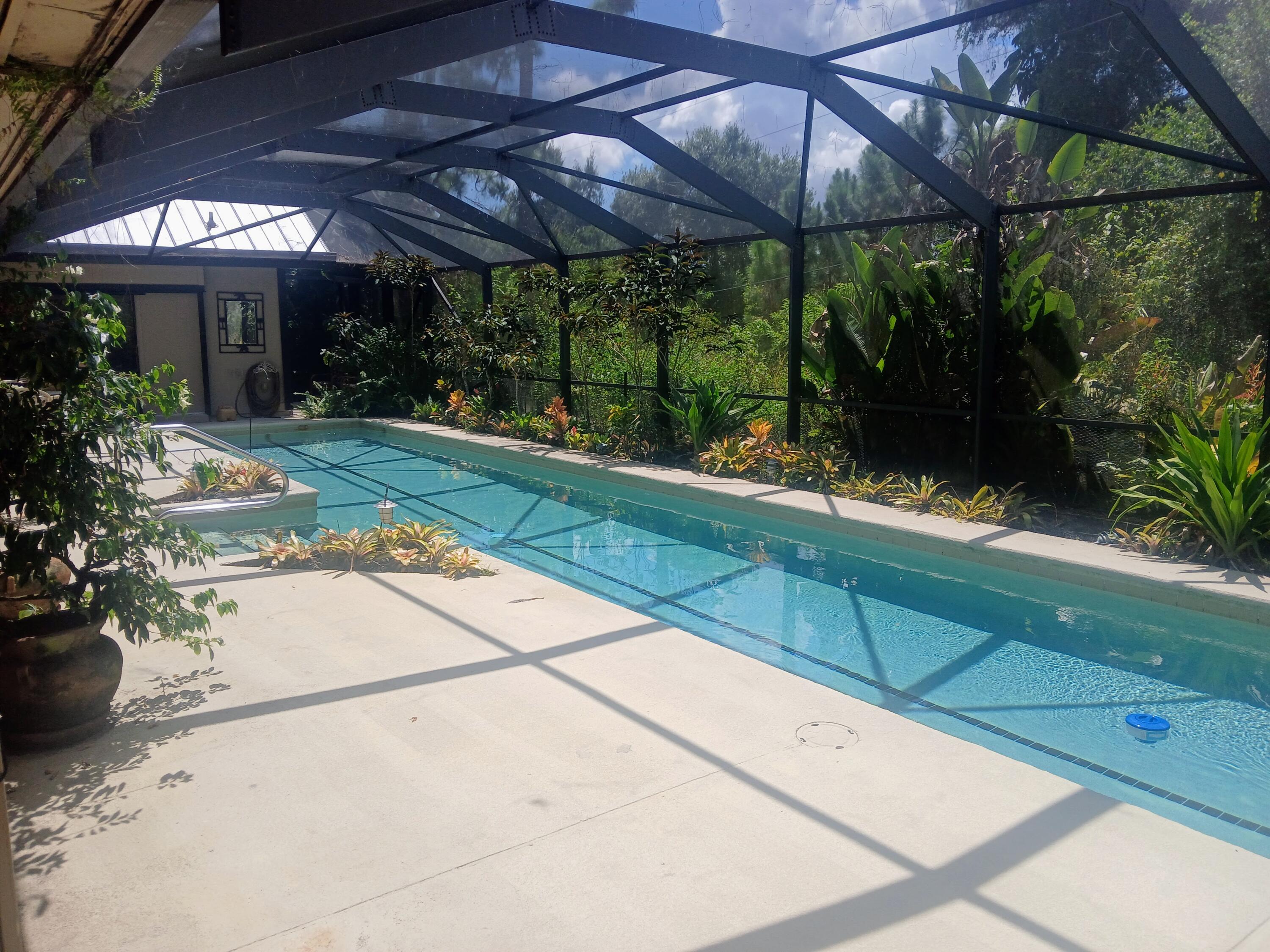 3217 Northwest Perimeter Road Palm City, FL 34990 - Photo 30 of 64 a view of a patio with table and chairs under an umbrella