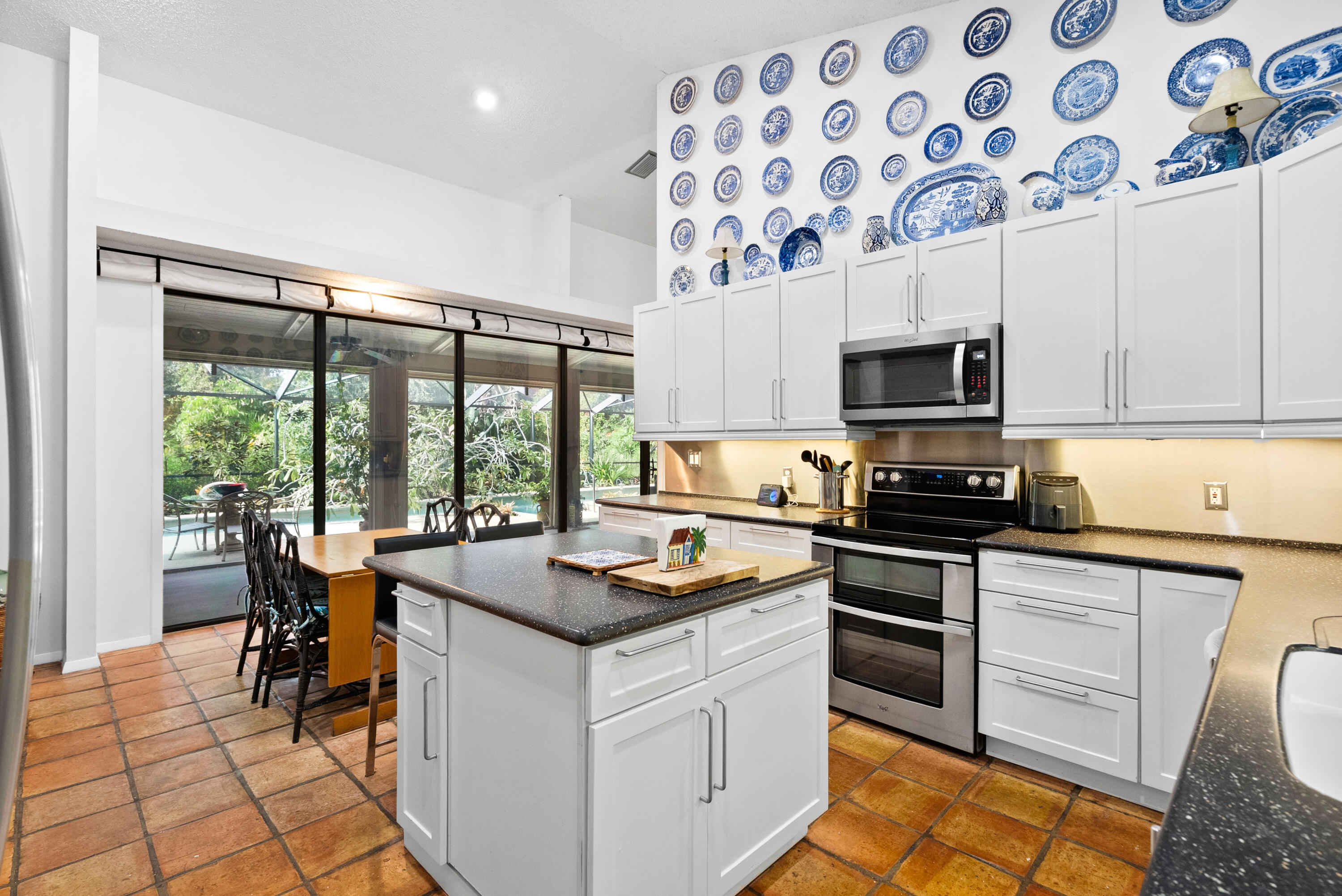 3217 Northwest Perimeter Road Palm City, FL 34990 - Photo 4 of 64 a kitchen with stainless steel appliances granite countertop a stove a sink and a microwave