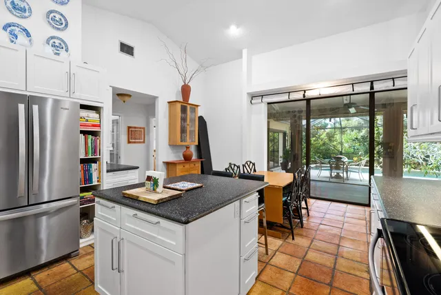 a kitchen with stainless steel appliances granite countertop a refrigerator and a stove