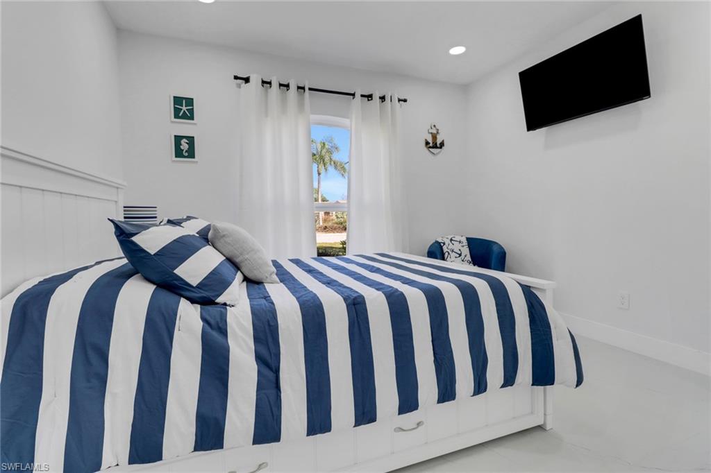 172 Plantation Circle Naples, FL 34104 - Photo 15 of 36 a bedroom with a bed tv and a window