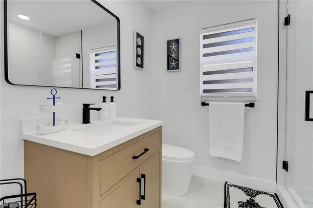 a bedroom with a bed tv and a window