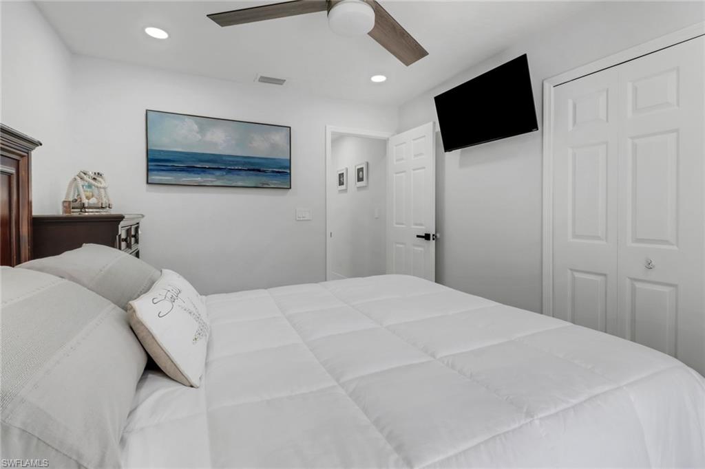 172 Plantation Circle Naples, FL 34104 - Photo 19 of 36 a bedroom with a bed and a flat screen tv