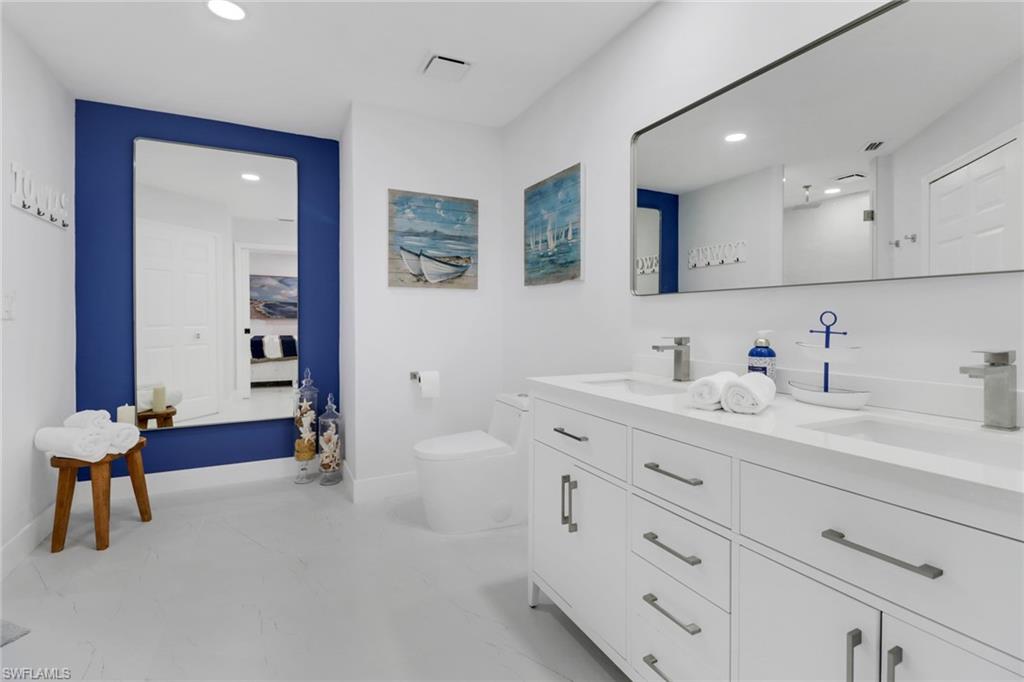 172 Plantation Circle Naples, FL 34104 - Photo 24 of 36 a bathroom with double vanity sink a mirror and shower