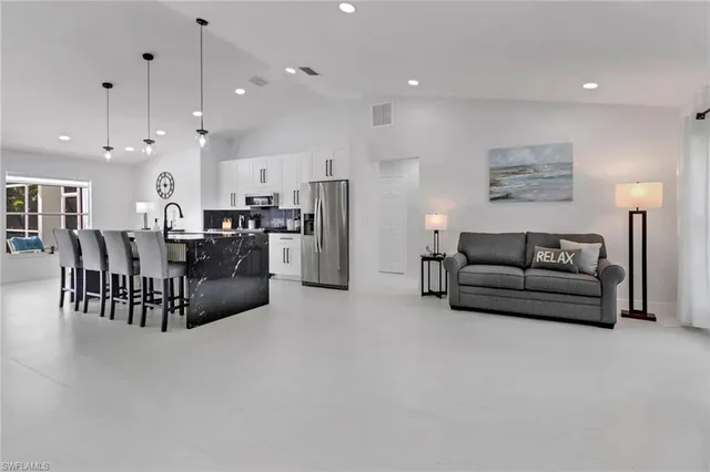 a living room with furniture and kitchen view