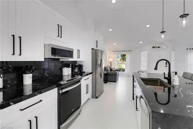a kitchen with stainless steel appliances granite countertop a sink and a stove top oven