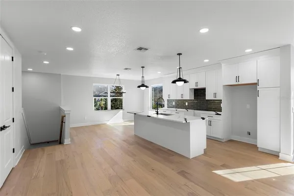 a kitchen with stainless steel appliances kitchen island hardwood floor sink and stove