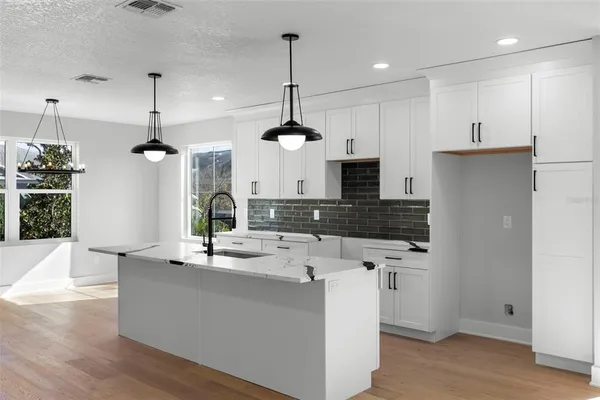 a kitchen with kitchen island a sink and a refrigerator
