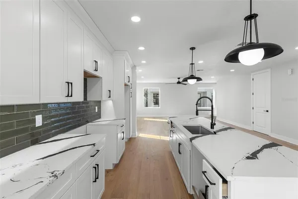 a kitchen with stainless steel appliances granite countertop a sink a stove and a refrigerator