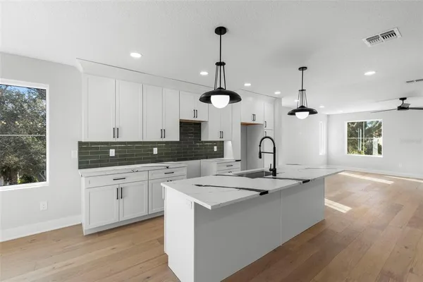 a kitchen with kitchen island white cabinets and sink