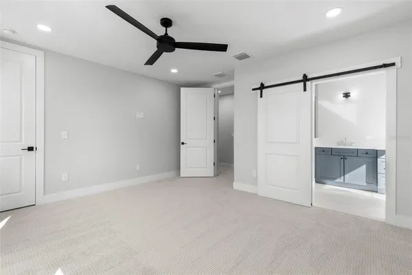 a view of a big room with a ceiling fan and refrigerator