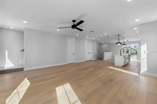 a view of a big room with kitchen and windows