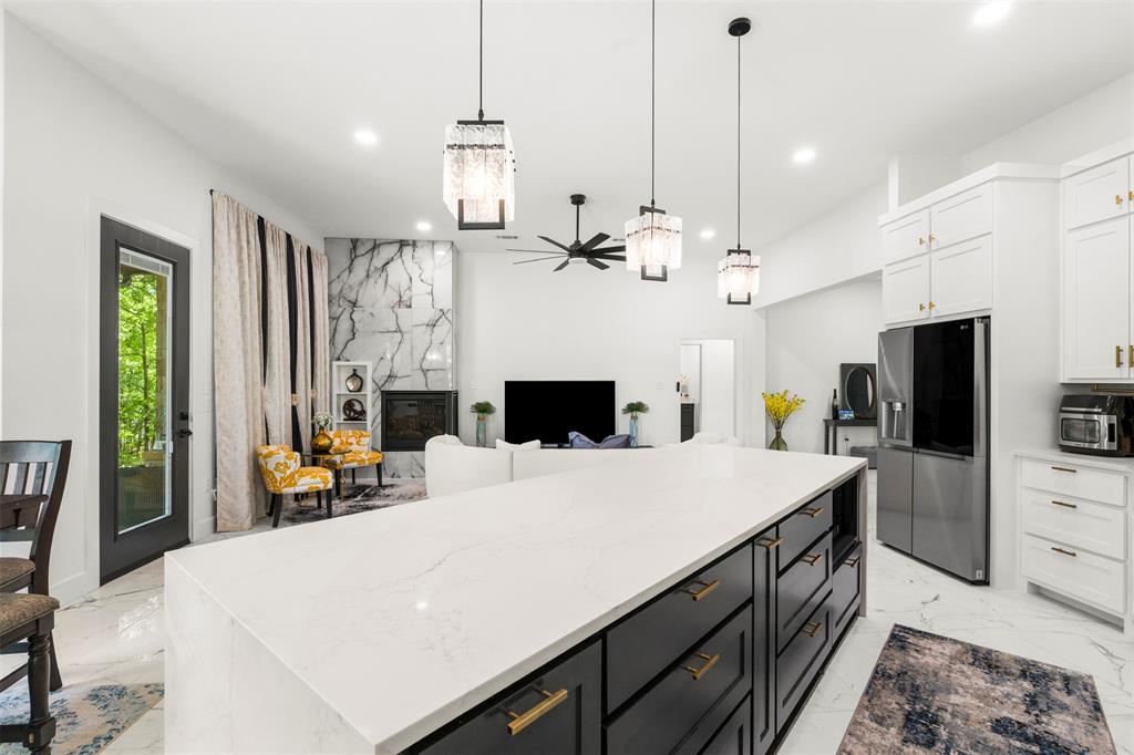 265 Shadow Oaks Streetman, TX 75859 - Photo 11 of 40 a large kitchen with sink a refrigerator and chandelier
