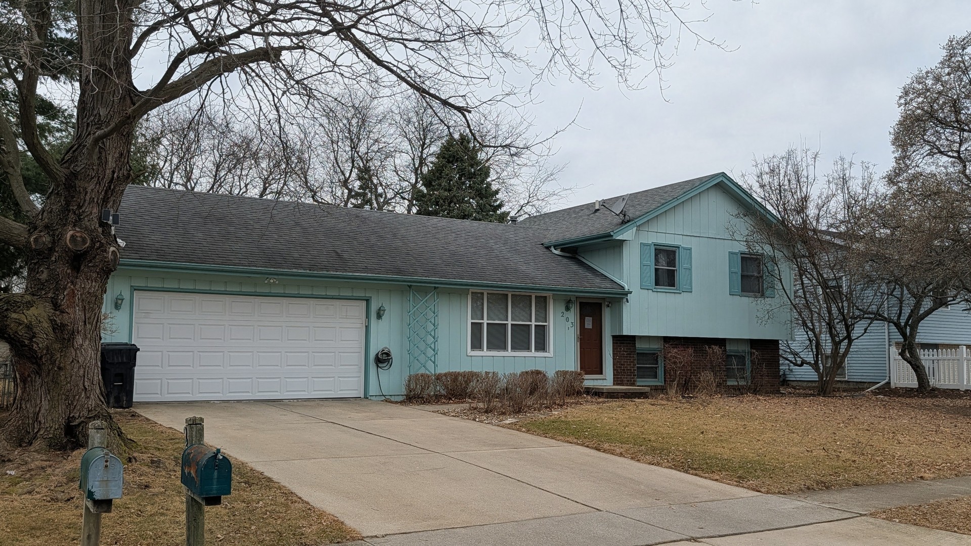a front view of a house with yard and trees