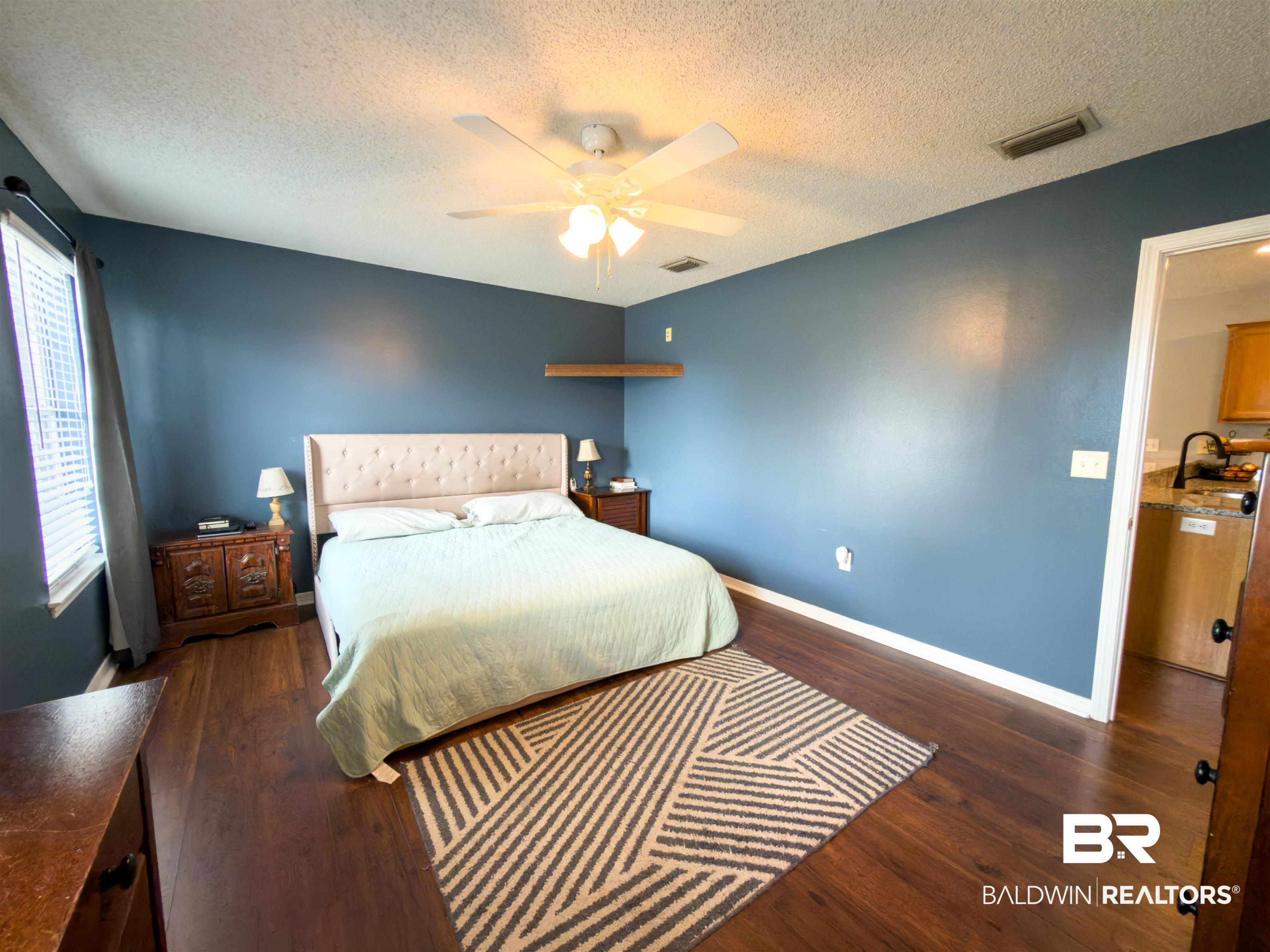 129 Pennbrooke Loop Foley, AL 36535 - Photo 27 of 44 Bedroom featuring dark wood finished floors, ceiling fan, and a textured ceiling