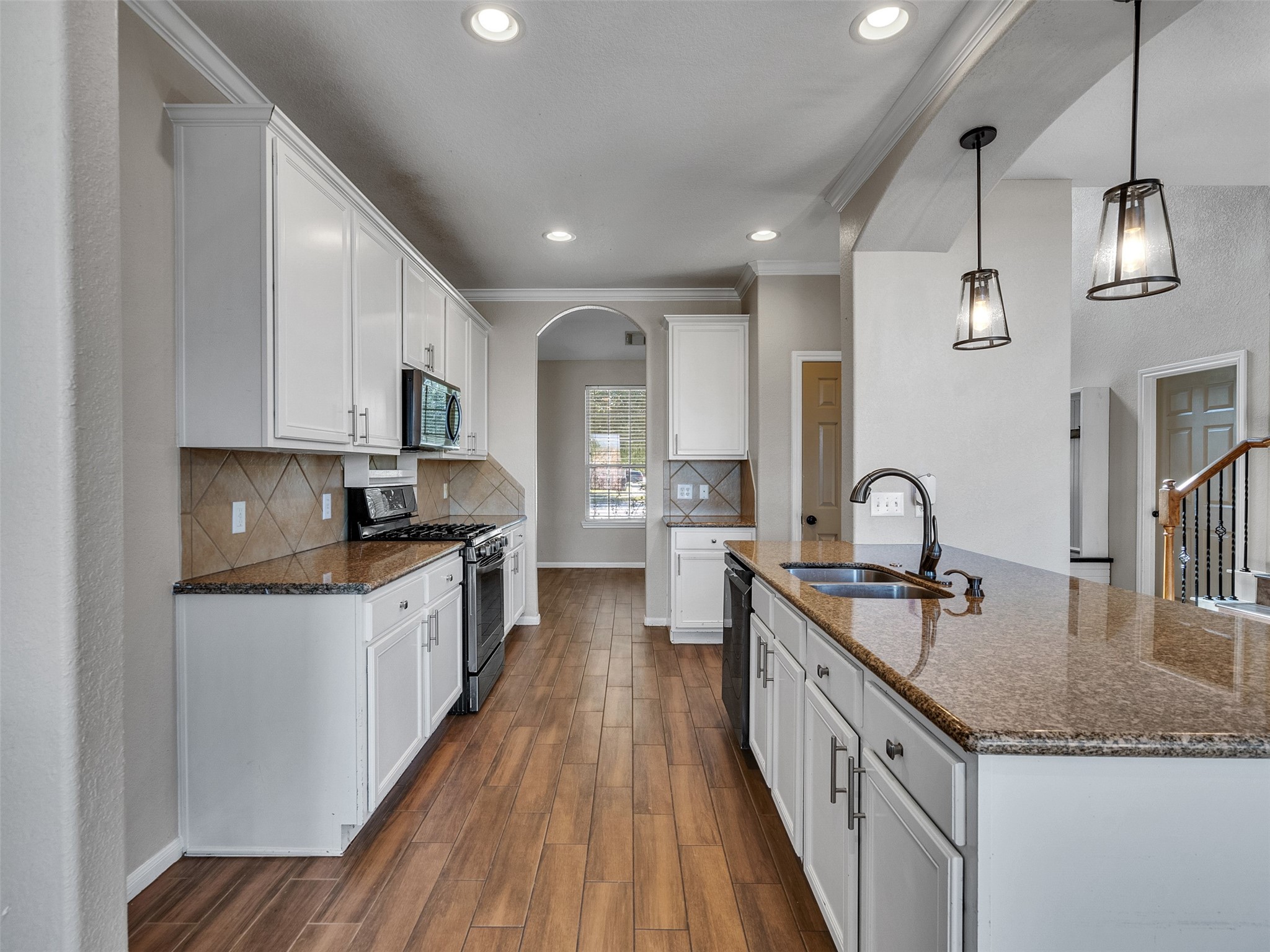 6014 Flagg Ranch Court Spring, TX 77388 - Photo 9 of 37 a kitchen with granite countertop kitchen island a sink a counter space stainless steel appliances and cabinets