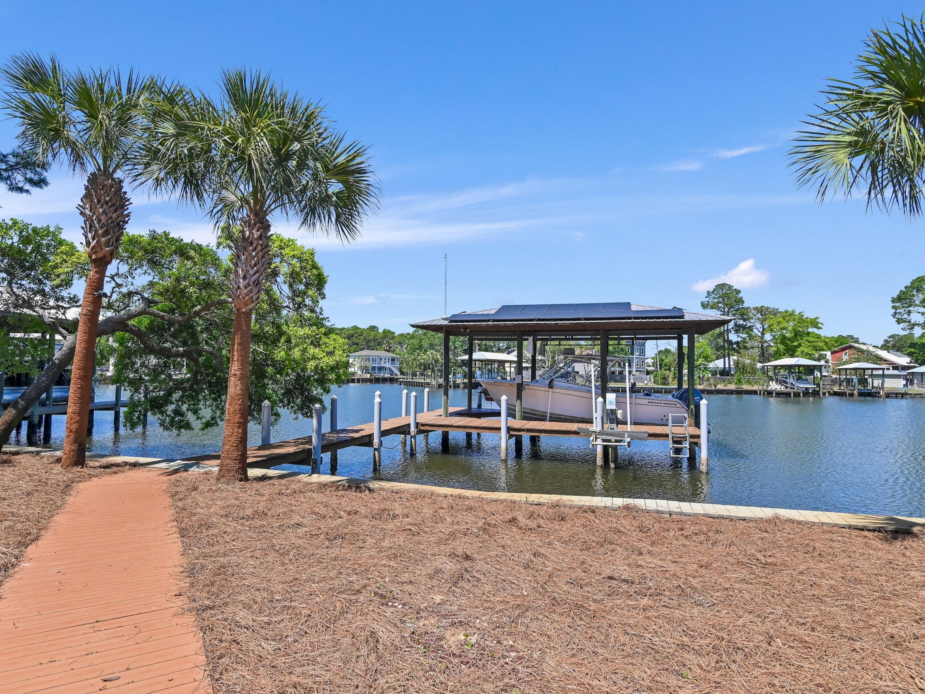 182 My Way Santa Rosa Beach, FL 32459 - Photo 32 of 39 a view of a swimming pool with a table and chairs under palm trees
