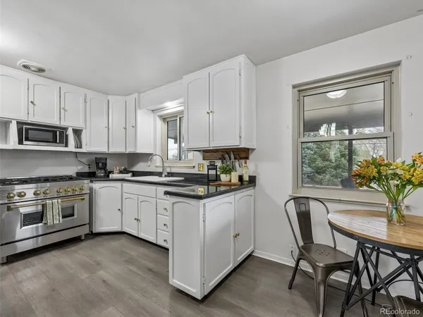 a kitchen with granite countertop white cabinets and stainless steel appliances
