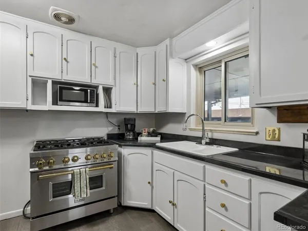 a kitchen with stainless steel appliances a refrigerator and white cabinets