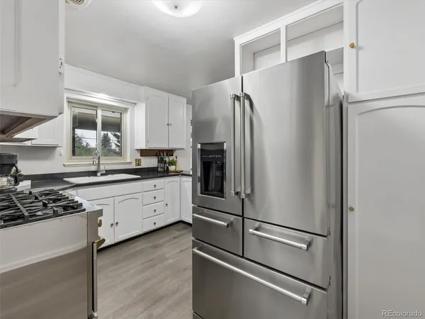 a kitchen with stainless steel appliances a table and chairs in it