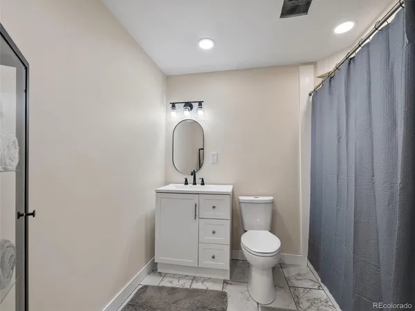 a bathroom with a sink a toilet and a mirror
