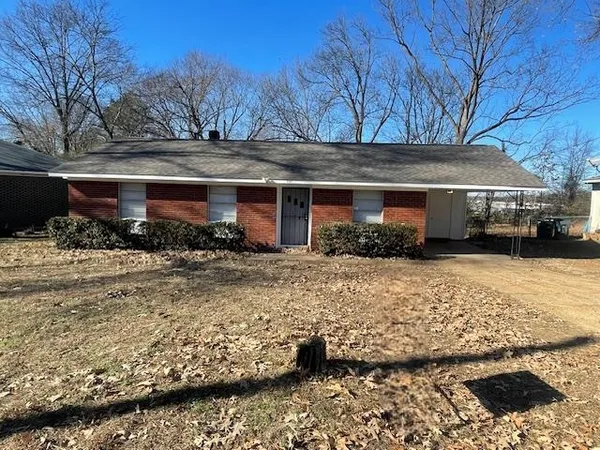 a front view of a house with a yard covered with snow
