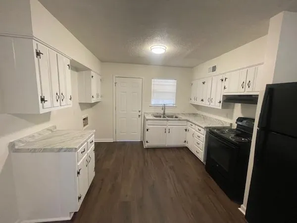 a kitchen with a sink a stove a refrigerator and cabinets