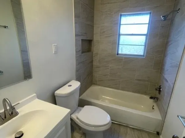 a white bath tub sitting next to a white toilet and sink