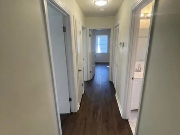 a view of a hallway with wooden floor