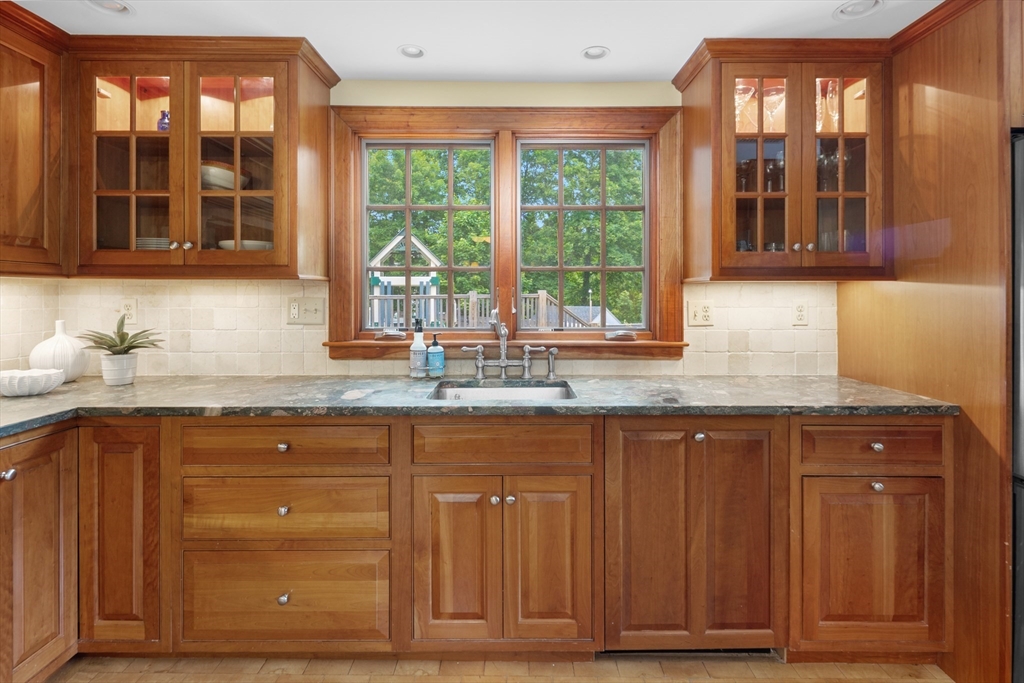 15 Hawthorne Road Hingham, MA 02043 - Photo 9 of 35 a kitchen with granite countertop wooden cabinets a sink and dishwasher next to a window