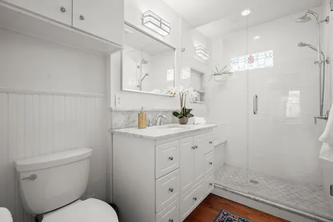a bathroom with a sink a toilet and shower