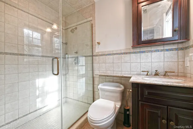 a bathroom with a granite countertop toilet sink and shower
