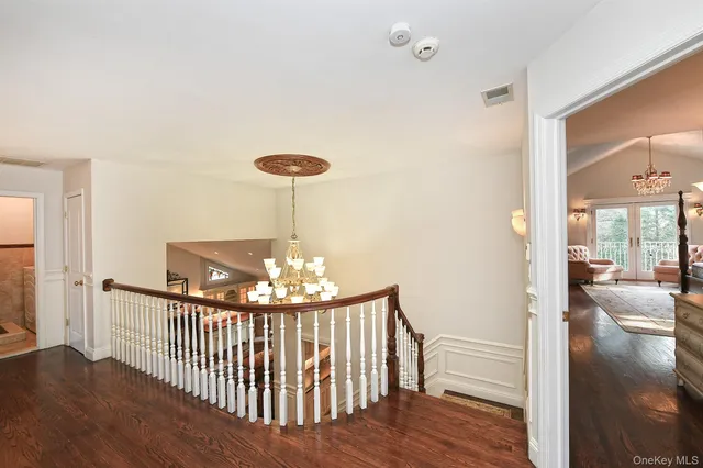 a view of a livingroom with wooden floor and chandelier