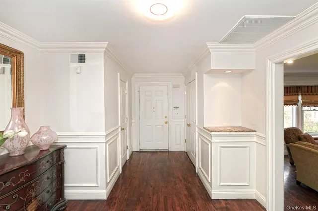 a view of a hallway with wooden floor and cabinet