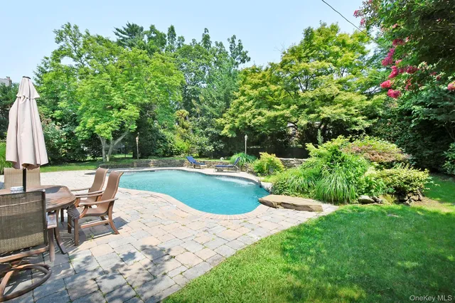a view of backyard with swimming pool and patio