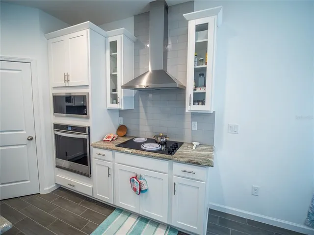 a kitchen with a stove and white cabinets