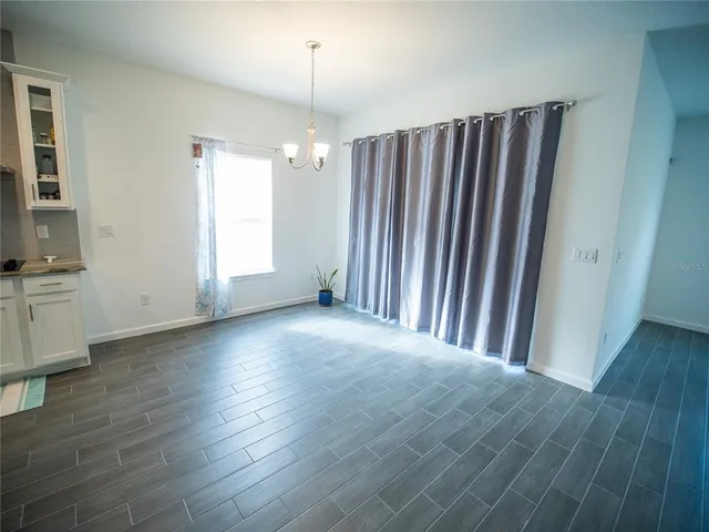 an empty room with wooden floor fireplace and staircase
