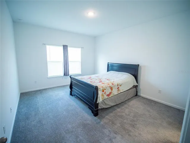 a bed sitting in a bedroom next to a window