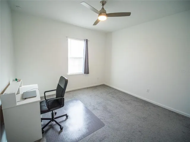a view of a workspace with furniture and a window