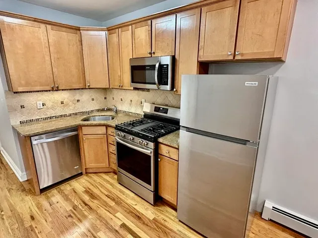 a kitchen with granite countertop white cabinets and white appliances