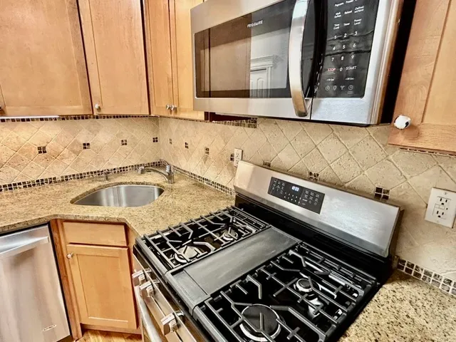 a kitchen with a stove a sink and a window