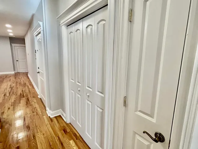 a view of a hallway with wooden floor and entryway