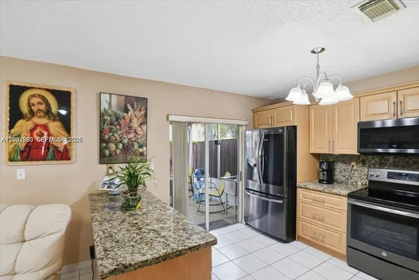 a kitchen with stainless steel appliances granite countertop a sink stove and microwave