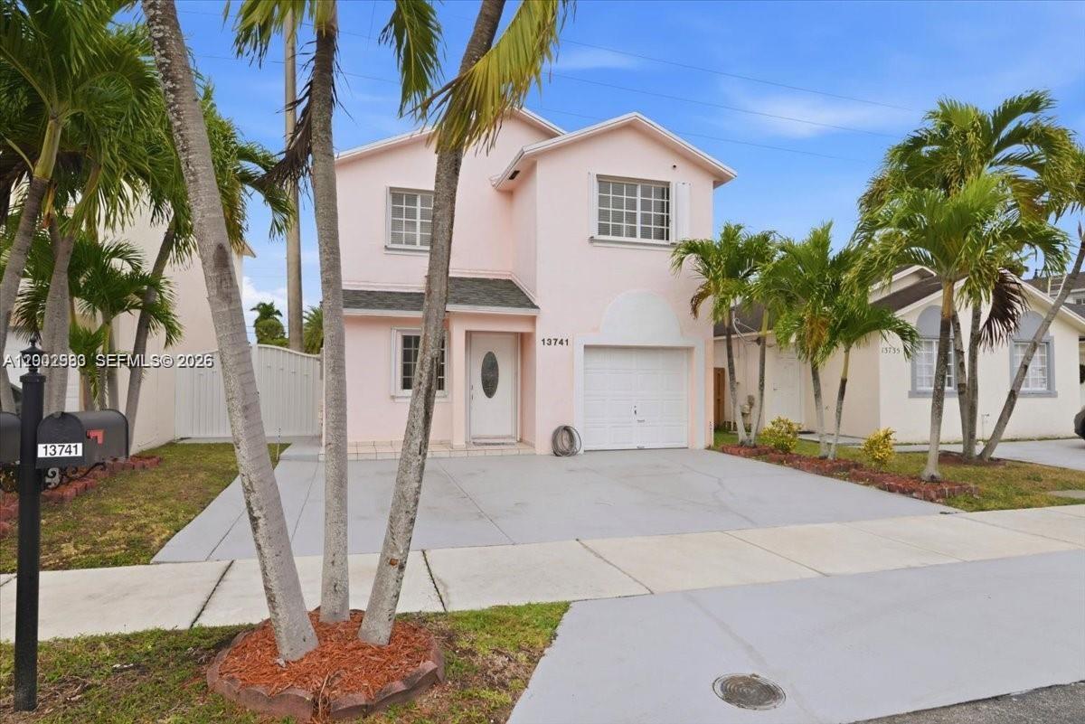 13741 Southwest 160th Terrace Miami, FL 33177 - Photo 2 of 34 a front view of a house with garden