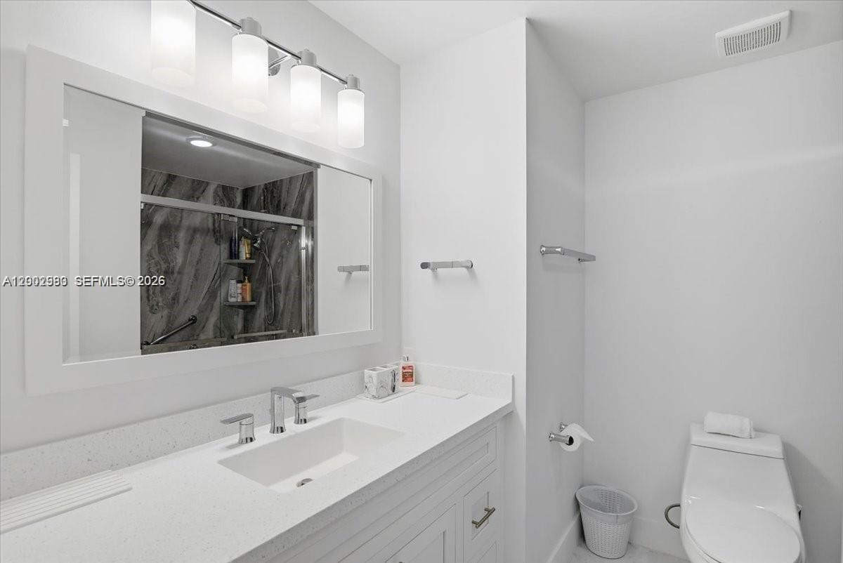 13741 Southwest 160th Terrace Miami, FL 33177 - Photo 26 of 34 a bathroom with a toilet a sink and mirror