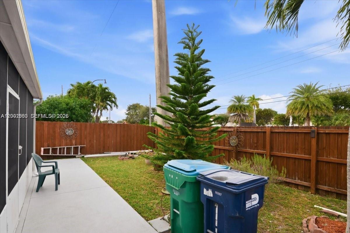 13741 Southwest 160th Terrace Miami, FL 33177 - Photo 32 of 34 a view of a backyard with chairs potted plants with wooden fence