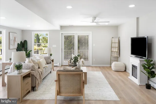 a living room with furniture a flat screen tv and a large window