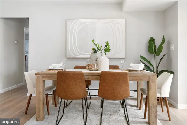a dining room with furniture and a potted plant