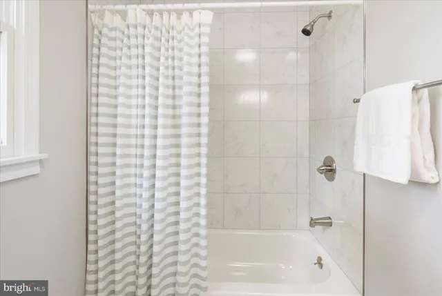 a bathroom with a shower curtain and a bath tub