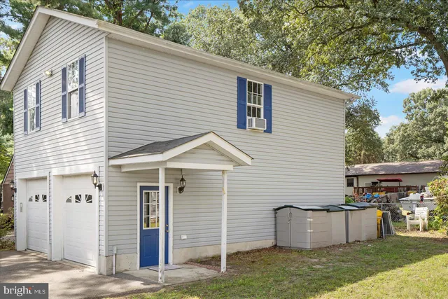a view of a white house with a yard and a large tree